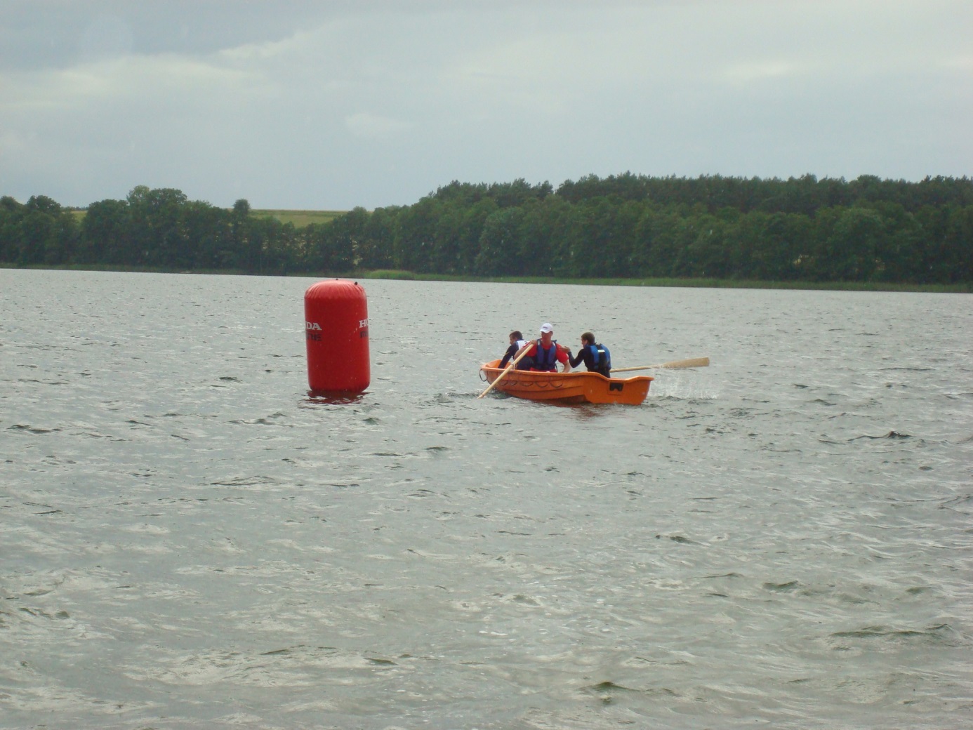 Druhowie R. Pęzowicz, J. Woźniak, T. Tarasiński wykonują manewr zawracania w konkurencji wyścig łodzi wiosłowych