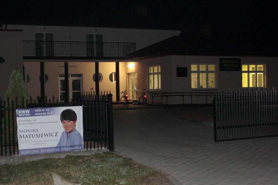 Baner wyborczy wiszący na ogrodzeniu Domu Ludowego w Kraśnicy