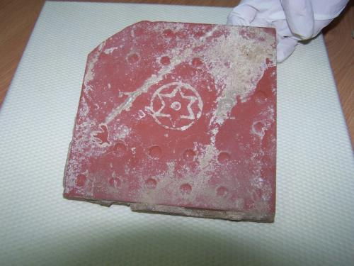 Spód płytki pochodzącej z wykopalisk. Zdjęcie dzięki uprzejmości Muzeum Walki i Męczęństwa w Treblince